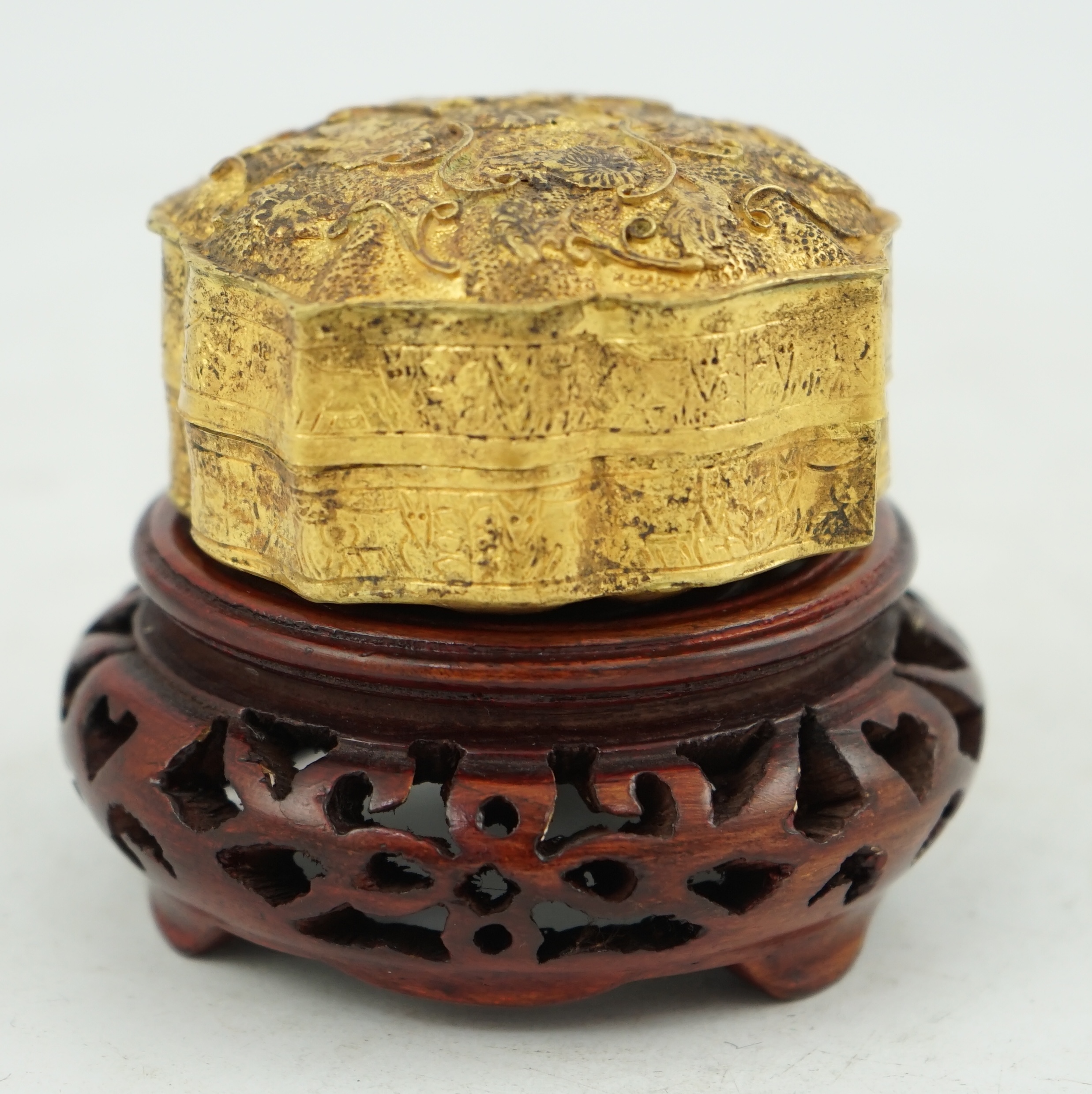 'An 18th century Chinese gilt repousee box & cover, probable Liao Dynasty', of petal lobed form, decorated with lions amid filigree scroll work, 5.5cm across